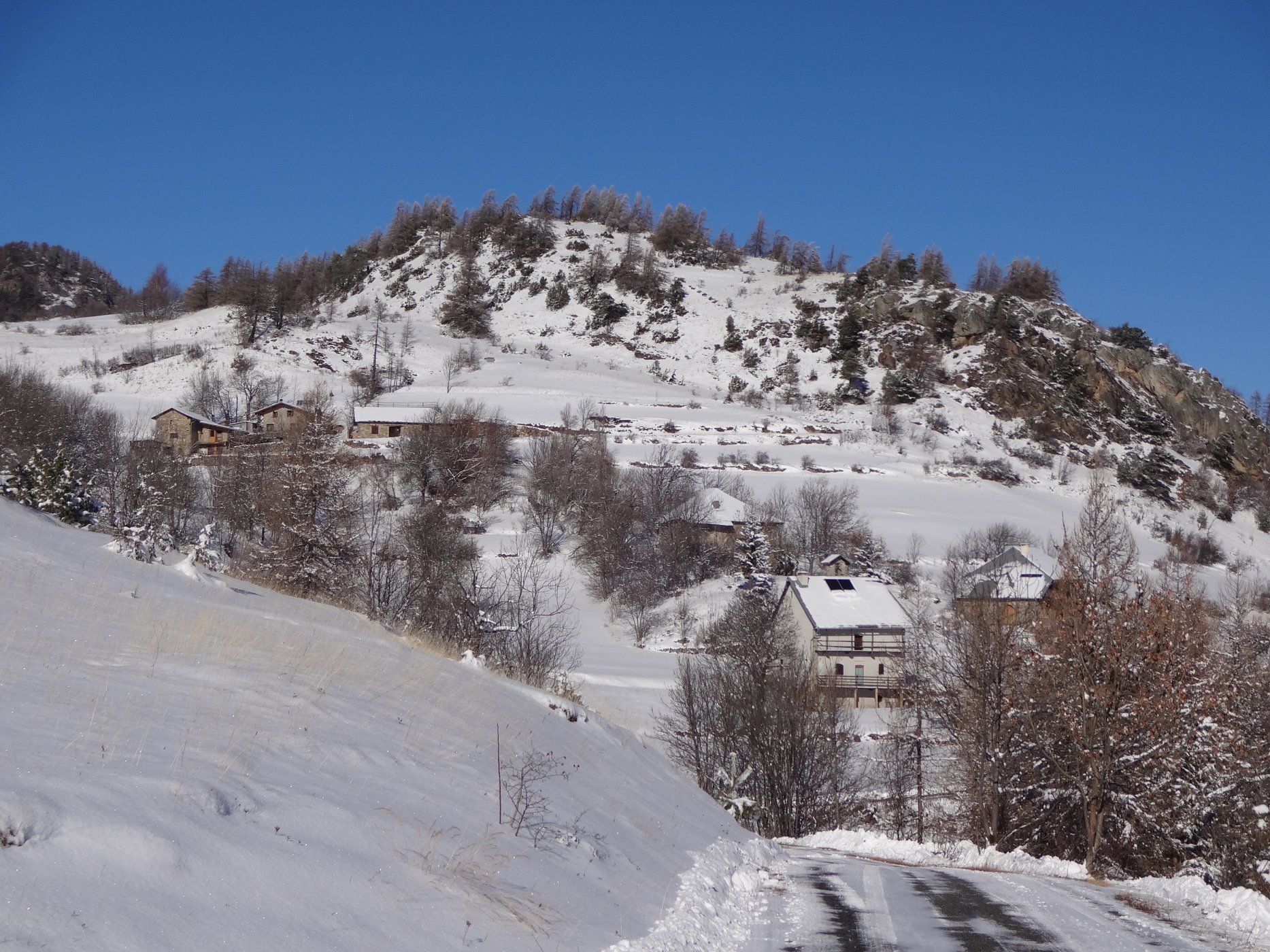 Truchet (1400m) point de départ habituel des itinéraires. Les chalets en bas correspondent aux Lajards de la carte IGN, tandis que ceux du haut seraient ceux de Truchet. L’usage locale désigne l’ensemble sous le vocable Truchet. La bosse (1570m) qui domine est appelée La Crose ou parfois Serre de Mikéou.