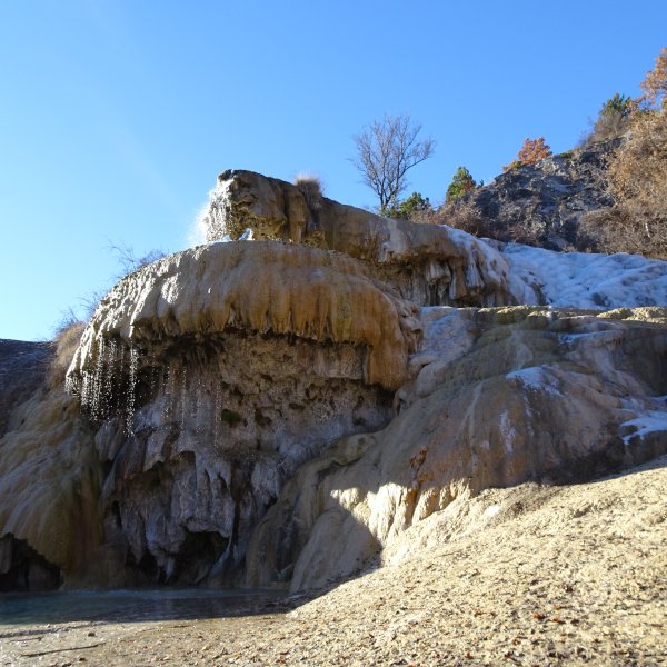 Fontaine pétrifiante en hiver. Seules les dérives de faible épaisseur suintant en bordure peuvent geler. Le flux principal dépassant les 20° en toutes saisons résiste sans tarir aux plus dures conditions.